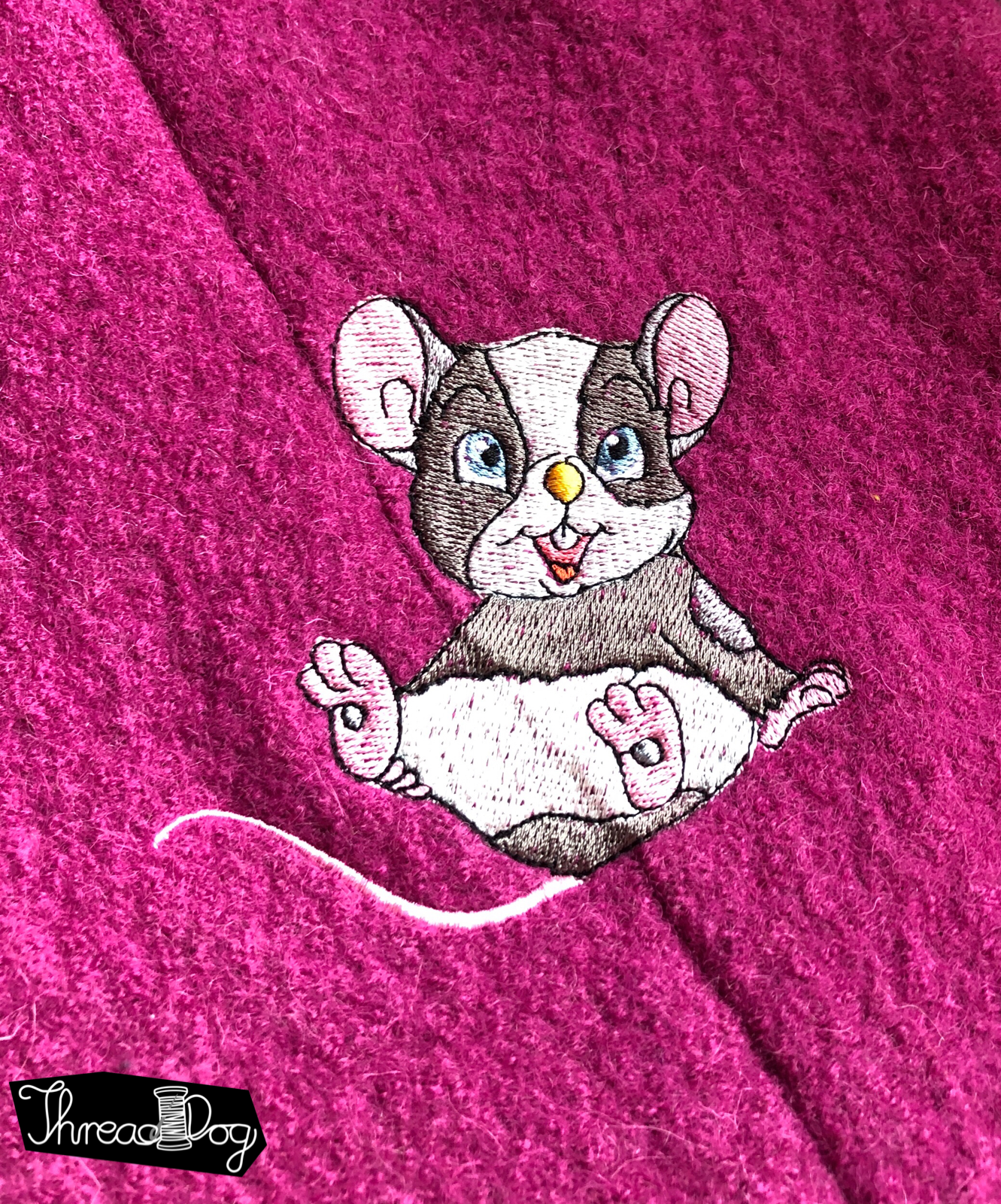 Pinker Wollwalkoverall mit Stickerei auf dem Rücken. Zu sehen ist eine Maus.